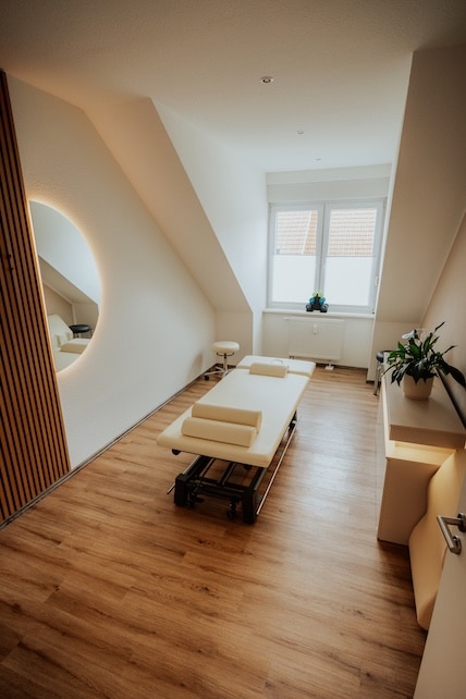 Behandlungsraum mit Therapieliege und Holzlamellenwand